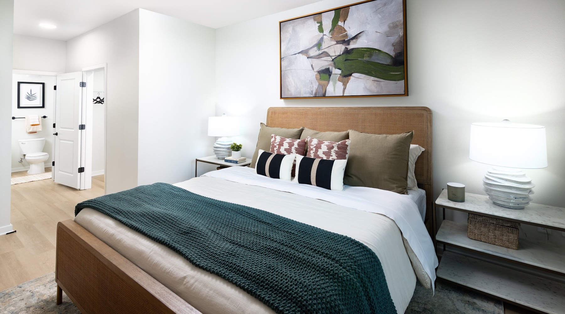 a bedroom with a bed and a painting on the wall